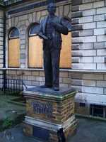 A statue of Clement Attlee outside Limehouse Library, which is boarded up. In April 2011 the statute was unveiled in its new permanent location outside the main library at Queen Mary, University of London.